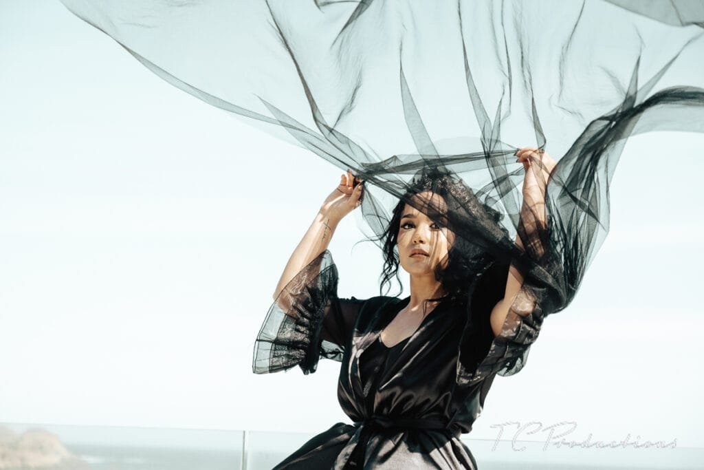 A woman holding a black fabric over her head